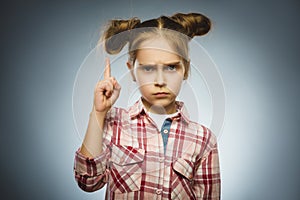 Displeased and contemptuous girl with threatens finger on gray background