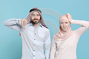 Displeased couple friends arabian muslim man wonam in keffiyeh kafiya ring igal agal hijab clothes isolated on blue