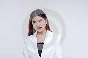 An displeased and disgusted young woman grimacing while looking at her left. Isolated on a white background