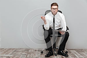 Displeased frustrated businessman in eyeglasses holding pc tablet