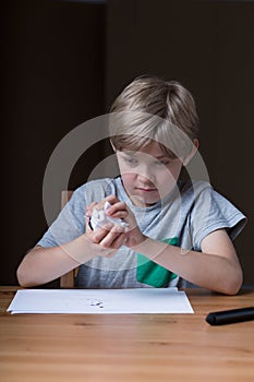 Displeased kid crumpling paper