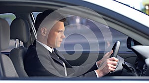 Displeased male in formal suit sitting on driver seat, stressful life, overwork