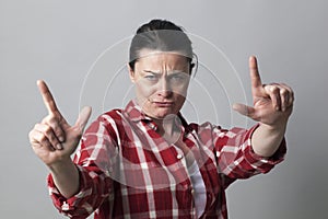 Displeased middle aged woman showing an aggressive hand gesture