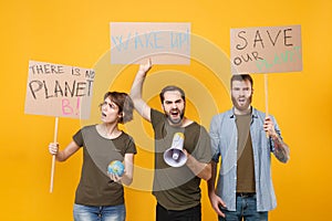 Displeased protesting people hold protest broadsheet placard world globe scream in megaphone isolated on yellow