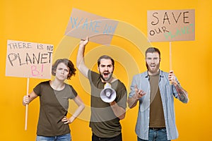 Displeased protesting young people hold protest signs broadsheet placard scream in megaphone isolated on yellow