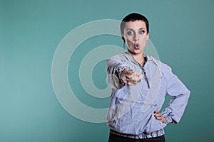 Displeased sad woman pointing index finger in front of camera screaming during studio shot