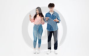 Displeased Students Couple Holding Smartphones Reading Negative Message, White Background