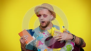 Displeased tired boring traveler tourist bearded stylish man in summer clothes on yellow background