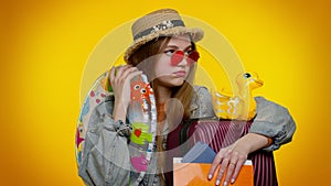 Displeased tired boring traveler tourist teen stylish girl in summer clothes on yellow background