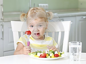 Displeased unhappy child eating healthy food