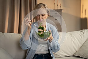 Displeased Woman Experiencing a Tasteless Salad at Home in Casual Attire