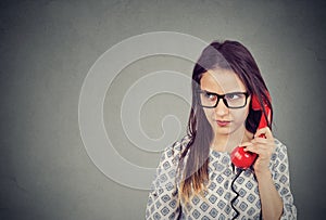 Displeased woman having dilemma during phone call