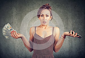 Displeased woman holding smart phone and money dollar cash, unhappy with cellular service charges