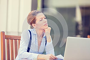 Displeased worried business woman sitting in front of laptop computer photo