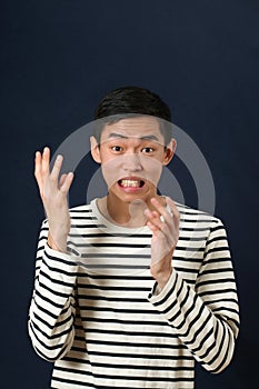 Displeased young Asian man gesturing with two hands