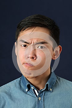 Displeased young Asian man making face photo