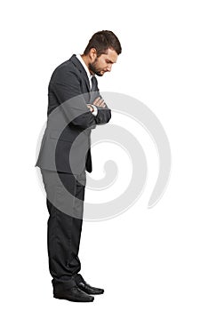 Displeased young businessman looking down