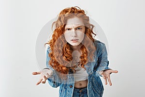 Displeased young foxy girl stretching to camera looking brutally gesturing over white background.