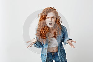 Displeased young foxy girl stretching to camera looking brutally gesturing over white background.