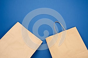 Disposable bag of brown kraft paper on a blue background, concept of rejection of plastic packaging