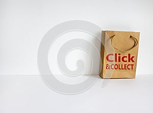 Disposable bag of kraft paper on a beautiful white background with expression `Click and collect`. Beautiful white background,