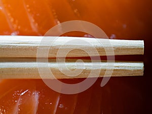 Disposable bamboo chopsticks and salmon sushi in background macro
