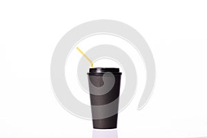 Disposable black paper cup with yellow plastic straw, isolated white background