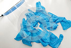 Disposable blue medical gloves lie on a white table