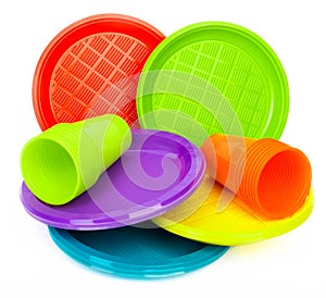 Disposable bright plastic plates and cups on white