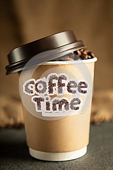 Disposable cup of coffee over vintage stone background with space for your text