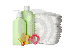 Disposable diapers, teether and toiletries on background