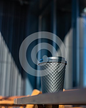 Disposable eco paper cup for hot drink with background of the city. Takeaway drink. Empty space for text, mockup