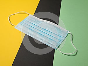 Disposable face mask for Corona on colored background with text free space