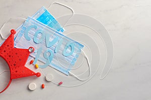 Disposable face mask and pills on light background