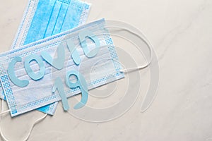 Disposable face mask and pills on light background