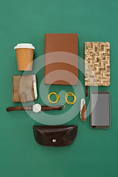 Disposable glass, wallet, organizer, wristwatch, pocketknife, mobile phone and sunglasses case on gr