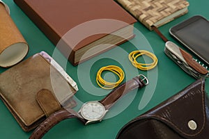 Disposable glass, wallet, organizer, wristwatch, pocketknife, mobile phone and sunglasses case on gr