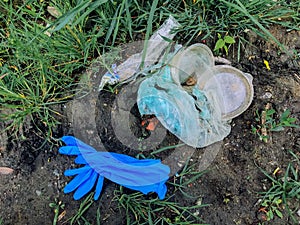 Disposable medical gloves on ground with single use plastic trash. How to dispose used medical gloves right after coronavirus