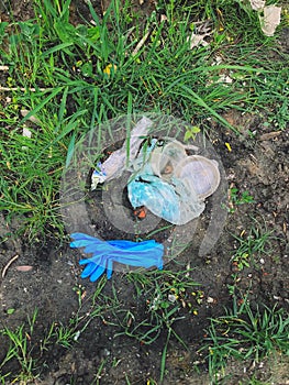 Disposable medical gloves on ground with single use plastic trash. How to dispose used medical gloves right after coronavirus