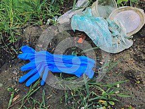 Disposable medical gloves on ground with single use plastic trash. How to dispose used medical gloves right after coronavirus