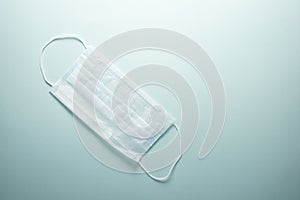 Disposable medical mask on a light background with place for text