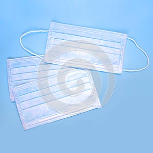 Disposable medical masks on a blue background. Flat lay, top view