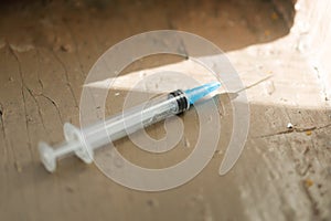 a disposable medical syringe lies on the street. The problem of drug addiction