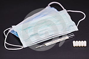 Disposable mouth masks with a mercury clinical thermometer and 5 tablets.