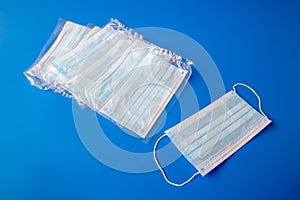 disposable new in packaging medical mask on a blue background