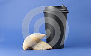 disposable paper coffee cup of hot coffee and sweet pastries on blue background. Coffee time, breakfast