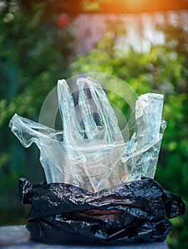Disposable plastic bags one enclosed in another close-up. Plastic bags for products on green blurred background. Waste, recycling