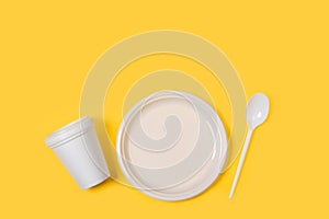 Disposable plastic white tableware set on a yellow background