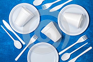 Disposable plastic whitetableware on a textured classic blue background