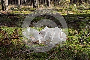 Disposable polyethylene bag on grass in forest. Recycling problem